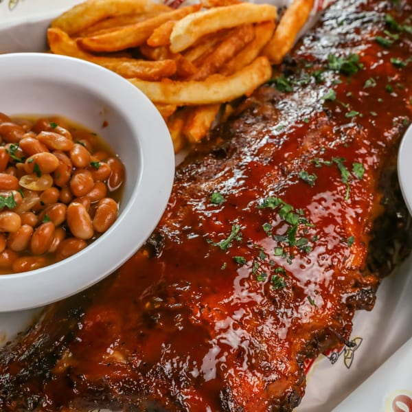 Stevie Tomato's BBQ ribs with baked beans and french fries, garnished with parsley.