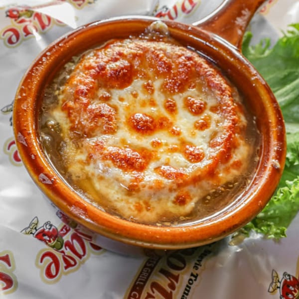 A bubbling crock of French onion soup with melted, golden-brown cheese on top, from Stevie Tomato's.